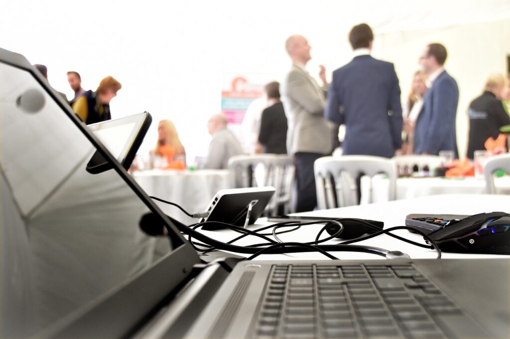 How to Choose the Right Event Company in Singapore for Your Next Corporate Project, Laptop with People Networking in Background